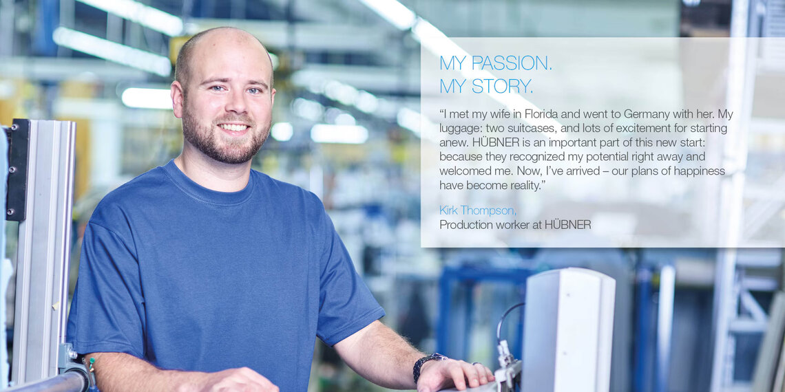 Mitarbeiter in einer Produktionshalle mit Zitat (auf englisch): "I met my wife in Florida and went to Germany with her. My luggage: two suitcases, and lots of excitement for starting anew. HÜBNER is an important part of this new start: because they recognized my potential right away and welcomed me. Now, I've arrived – our plans of happiness have become reality." Kirk Thompson, Production worker at HÜBNER.