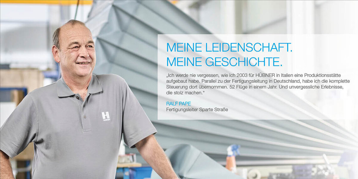 Mitarbeiter in Werkshalle mit Zitat: "Ich werde nie vergessen, wie ich 2003 für HÜBNER in Italien eine Produktionsstätte aufgebaut habe. Parallel zu der Fertigungsleitung in Deutschland, habe ich die komplette Steuerung dort übernommen. 52 Flüge in einem Jahr. Und unvergessliche Erlebnisse, die stolz machen." Ralf Pape. Fertigungsleiter Sparte Straße