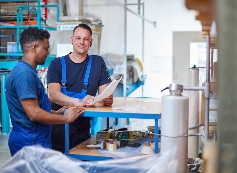 Zwei Angestellte besprechen sich in der Produktionshalle